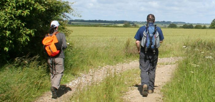 Two people walking along countryside track