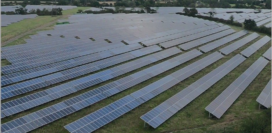 many rows of photovoltaic solar panels covering a large expanse of countryside