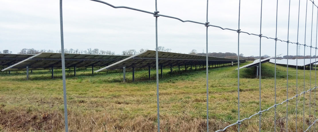 a view of chain link fence and a large amount of glass and metal, in other words, a solar farm
