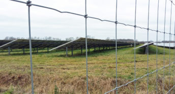 a view of chain link fence and a large amount of glass and metal, in other words, a solar farm