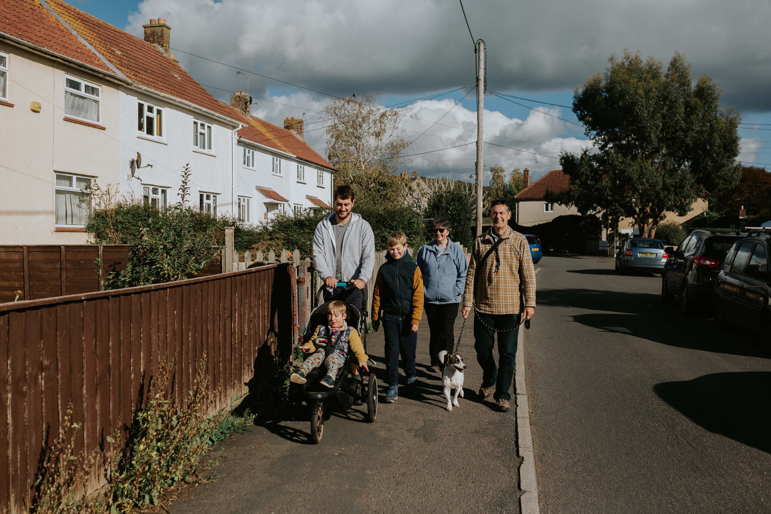 a family walking past affordable housing in a village