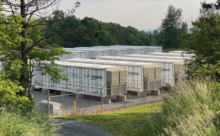 are battery energy storage system safe? image shows a dozen metal containers holding the batteries, behind a security fence