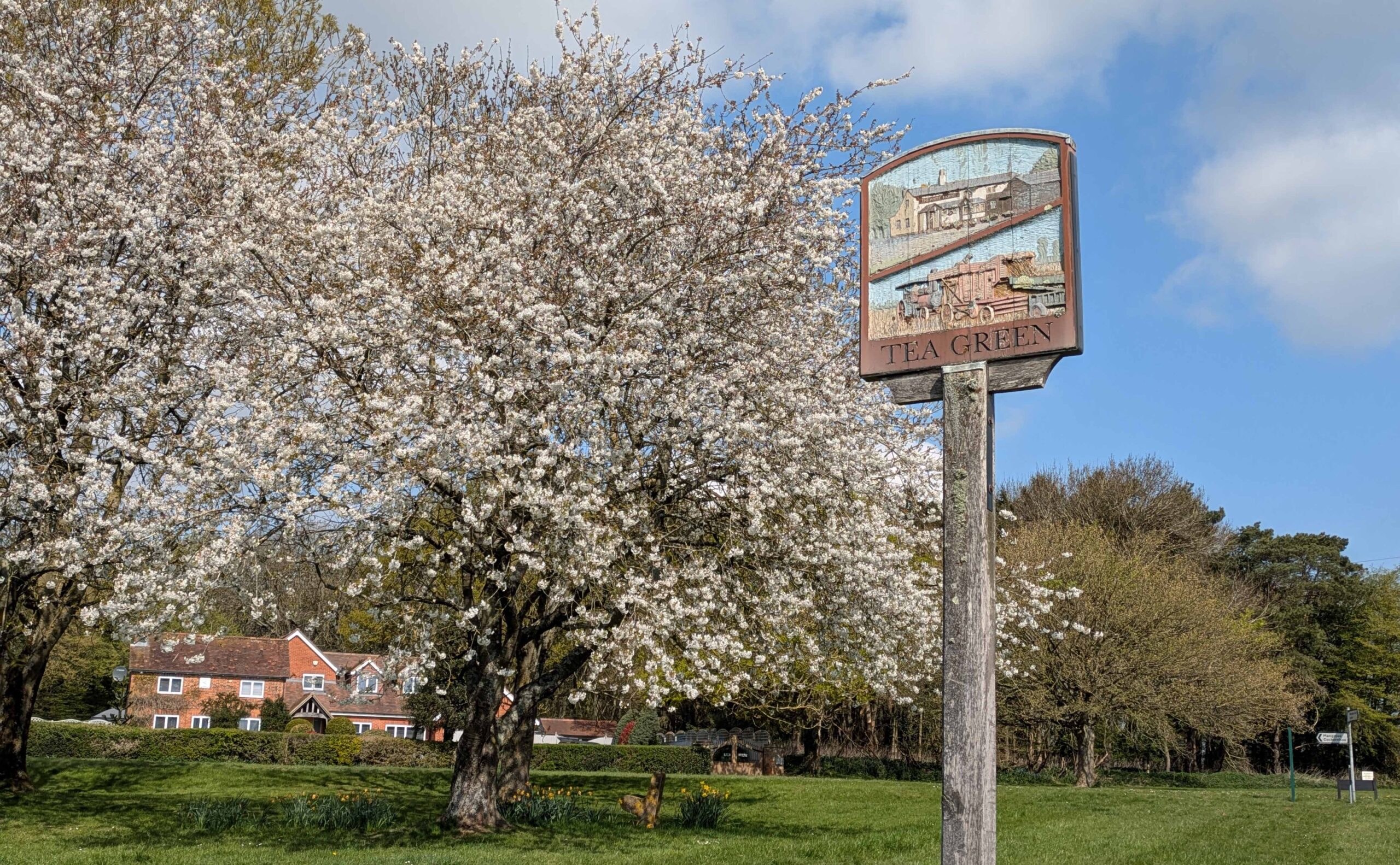 village sign and trees in blossom