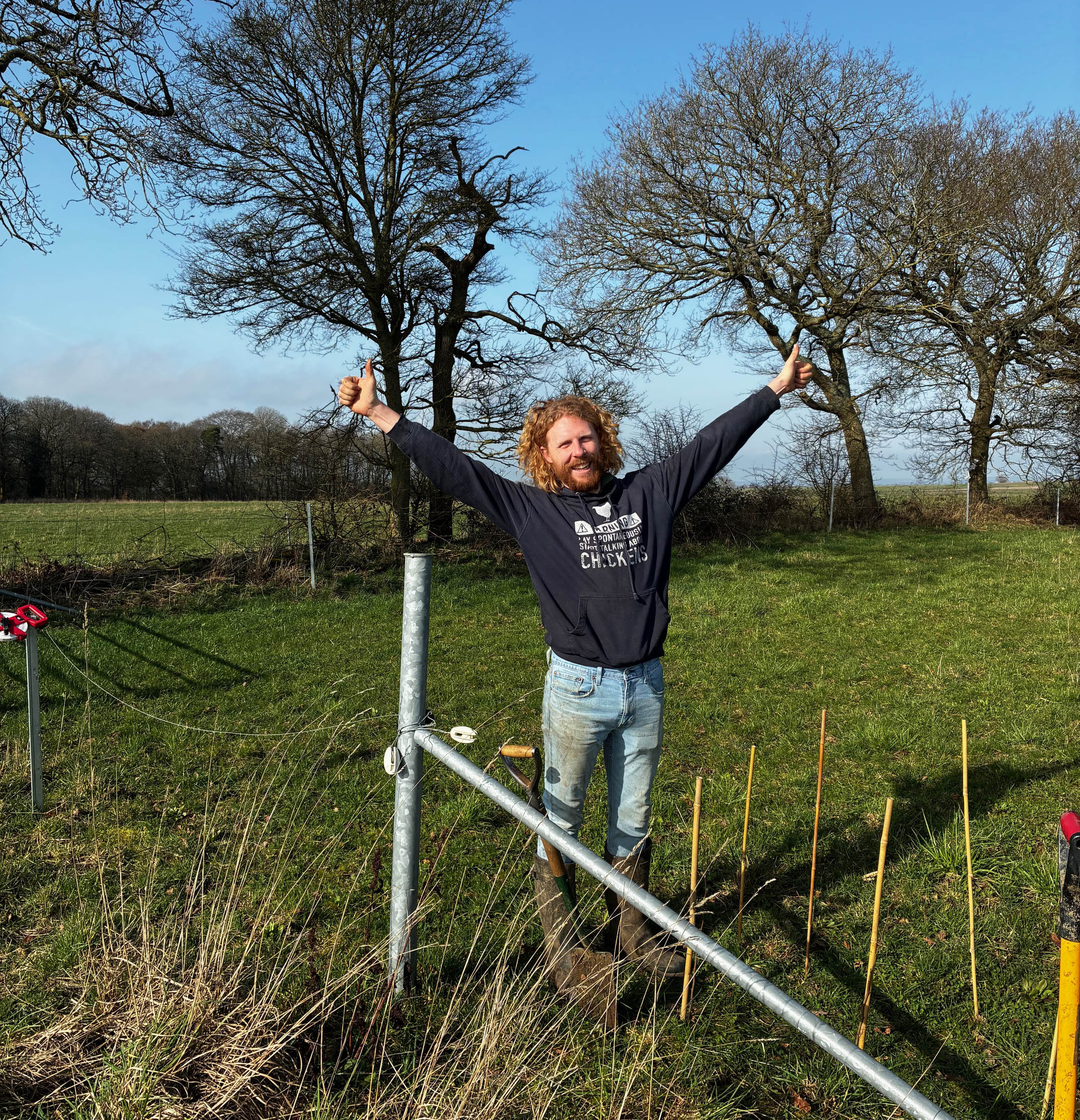 man holding his arms out in celebration at having planted a stretch of new hedgerow