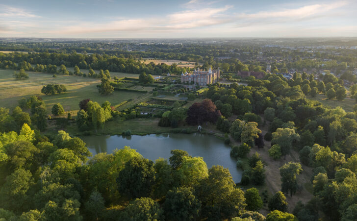 aerial view of Hatfield House and extensive parkland with woodlands, open countryside, and a lake